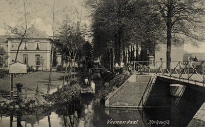 14706 Gezicht in de Kerkewijk met bebouwing en rijen loofbomen te Veenendaal; met rechts de brug over het Omleidingskanaal.